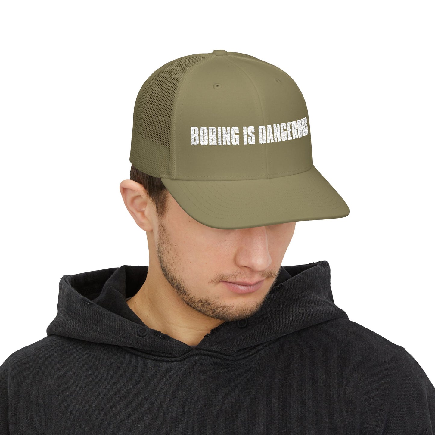 Person wearing a green cap with 'BORING IS DANGEROUS' text on a white background