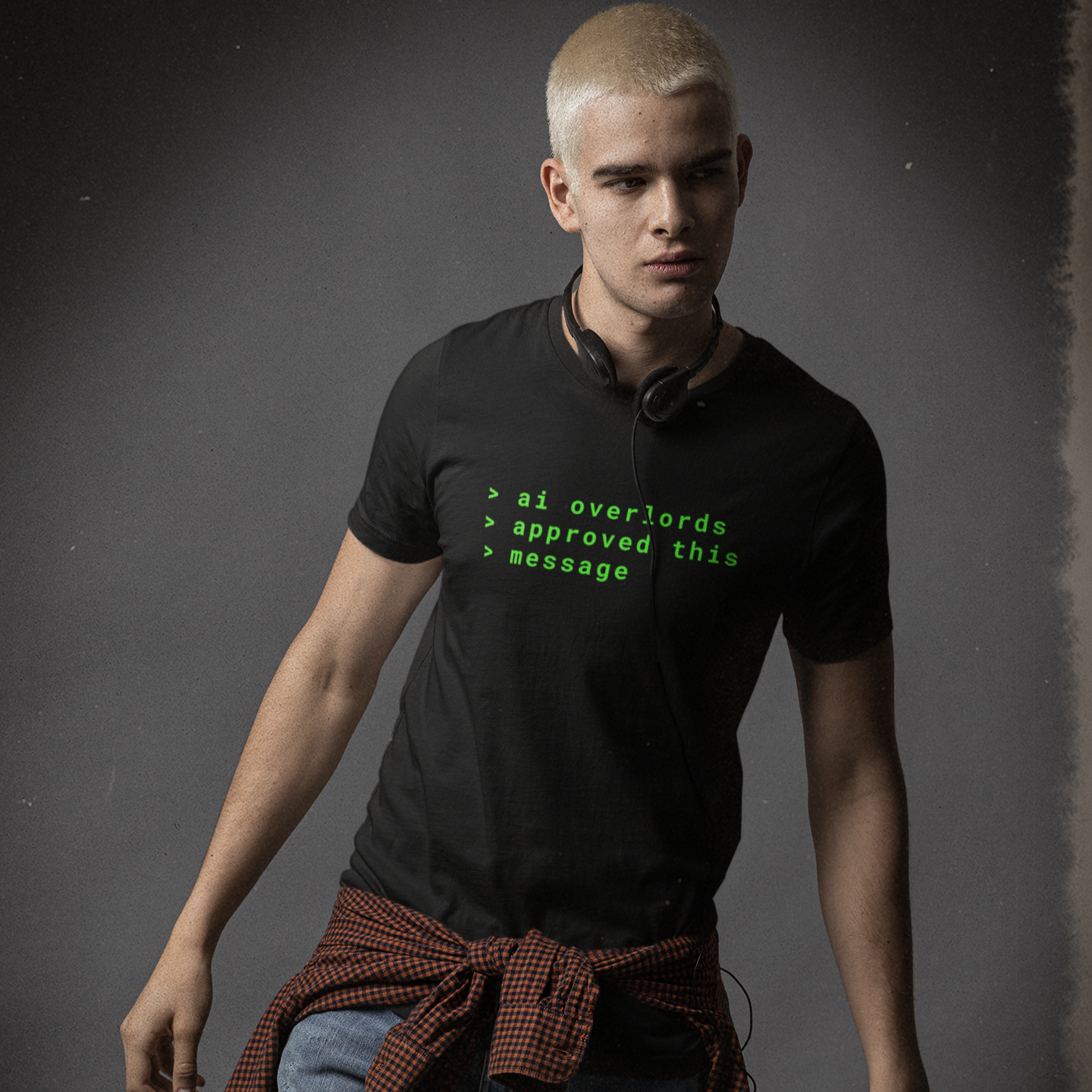 Man wearing a black t-shirt with text and a brown apron on a dark background