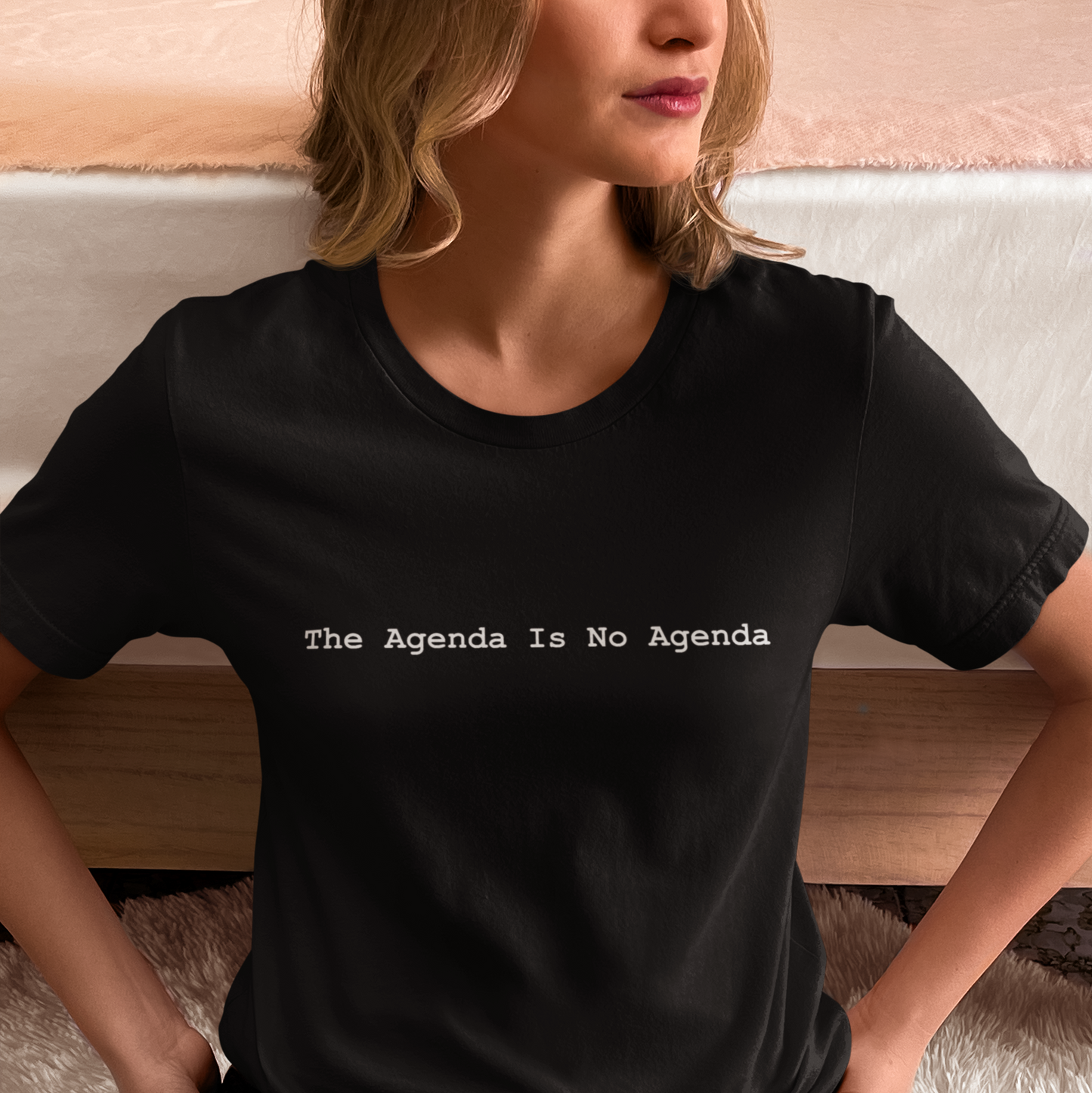 Person wearing a black t-shirt with 'The Agenda Is No Agenda' text.