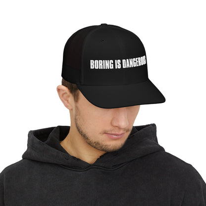Man wearing black hat with Boring is Dangerous white text.