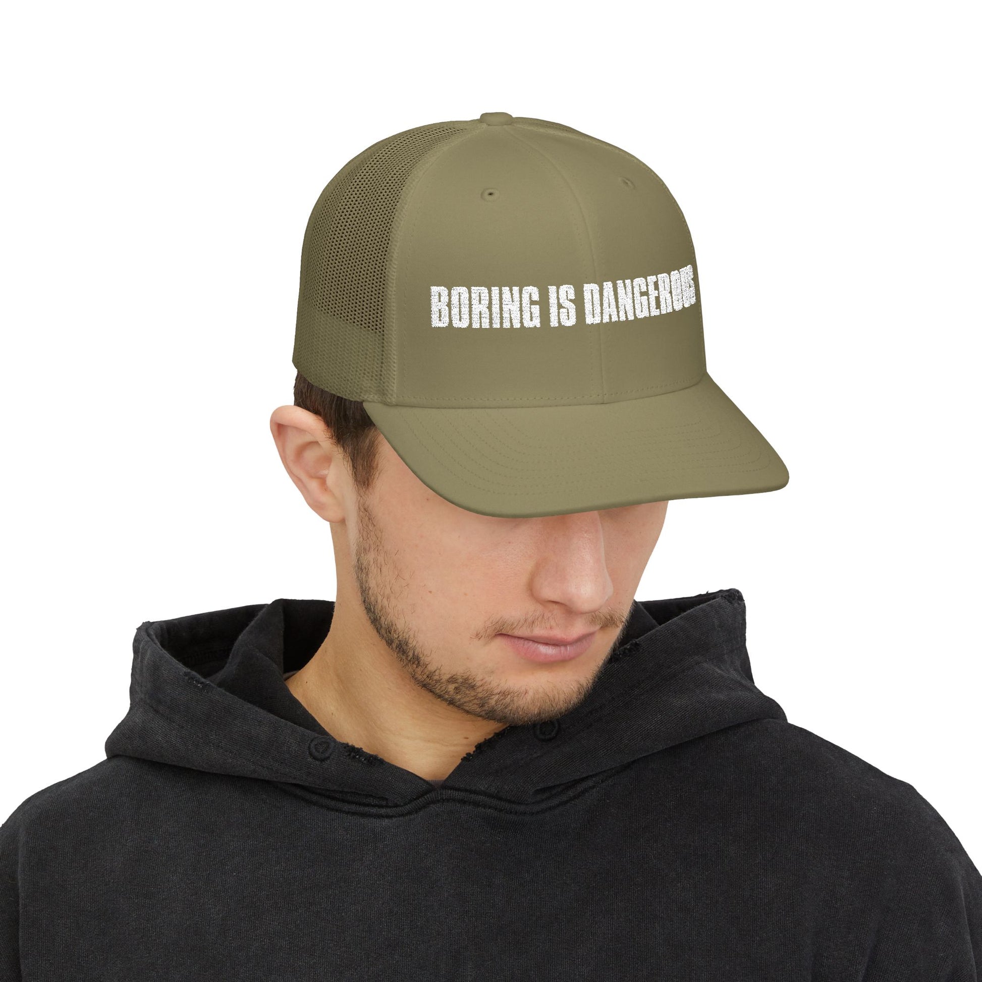 Person wearing a green cap with 'BORING IS DANGEROUS' text on a white background