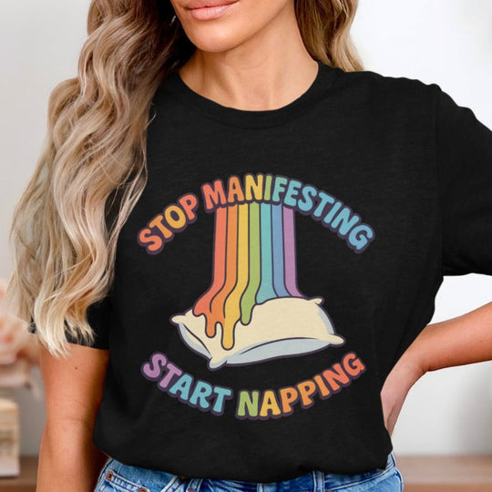 Person wearing a black t-shirt with colorful text and a rainbow design.