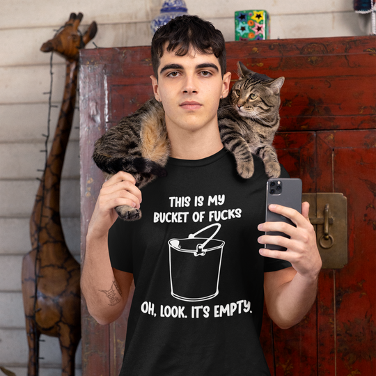 Person wearing a black t-shirt with graphic design and text, holding a phone, with a cat on their shoulder.
