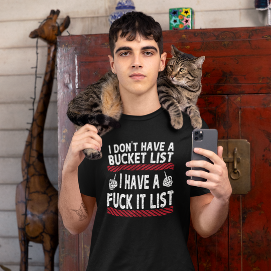 Person wearing a black t-shirt with a humorous design, holding a phone, with a cat on their shoulder.