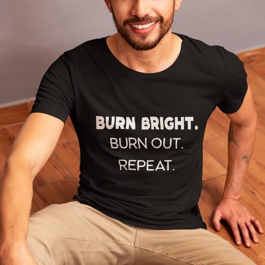 Person wearing a black t-shirt with 'BURN BRIGHT. BURN OUT. REPEAT.' text on a wooden floor.