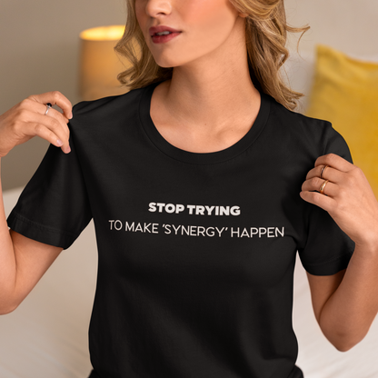 Person wearing a black t-shirt with text, sitting on a couch.