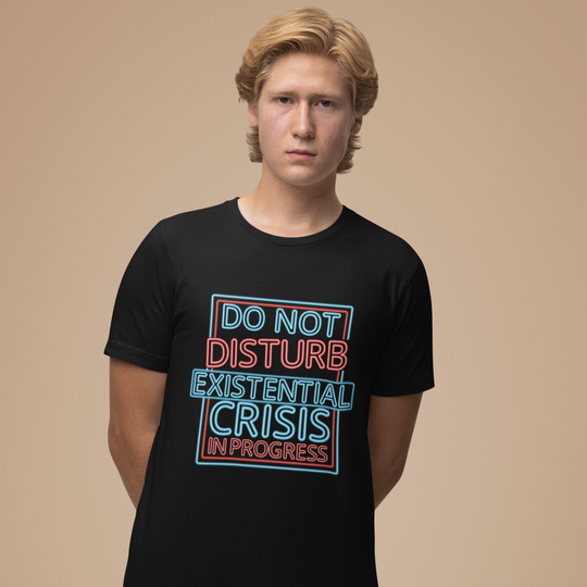 Person wearing a black t-shirt with colorful text on a beige background