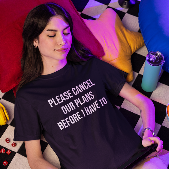 Woman wearing a t-shirt with text, lying on a checkered floor with snacks and drinks around.