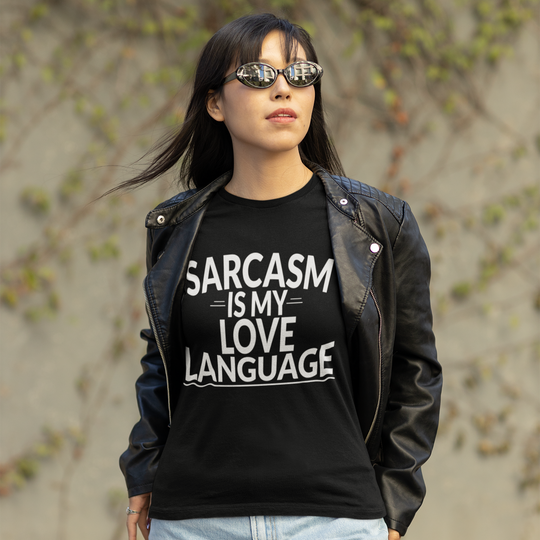 Person wearing a black t-shirt with 'SARCASM IS MY LOVE LANGUAGE' text, standing outdoors.